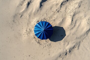 top view of blue umbrella on the sand