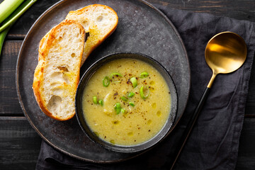 A cup of leek soup with toasted bread top view