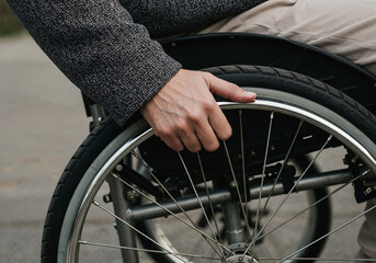 Close-up of a Person's Hand Gripping the Wheel of a Manual Wheelchair, Highlighting Mobility and Independence