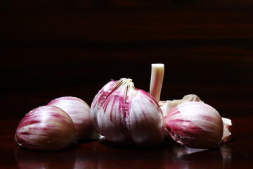 Garlic bulb on the rustic table under dramatic light. Brazilian seasoning.