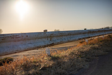 夕日に染まる錆びたガードレール