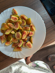 Fresh sliced figs served on a white plate, healthy organic snack.
