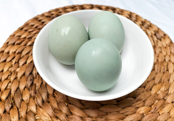 Serving salted duck eggs on white bowl with white background. Salted eggs that have finished the salting process. Selective focus.