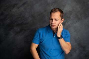 Man Touching His Cheek with a Pained Expression