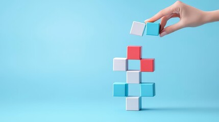 A hand placing a colorful block on top of a stack against a light blue background, symbolizing strategy and planning.