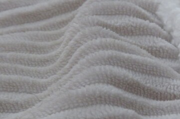 The gentle, undulating ridges of a white blanket create a calming, hypnotic pattern of pure comfort...