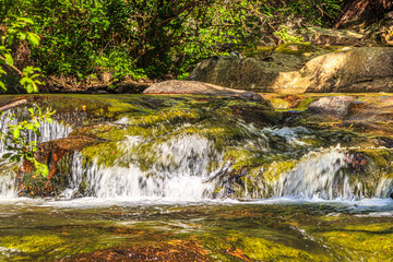 Fototapeta premium Landscape still shot of the Dure River in Brousse and Villaret in the South of France. Small waterfalls and undergrowth in Occitanie. 