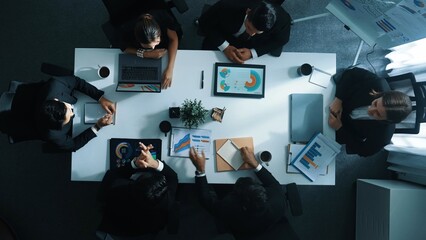 Top down aerial view of diverse business team listening manager present growth sales while giving a high five to encourage or motivate team. Group of people celebrate successful project. Directorate.