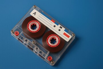 Retro audio cassette tape with red reels on blue background
