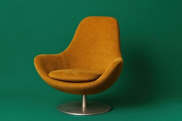 Golden modern lounge chair on green background with metal base
