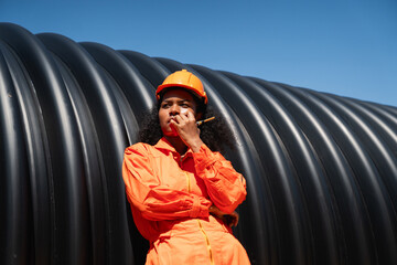 Engineers collaborate inside a massive steel pipe, constructing a tunnel for an industrial pipeline...
