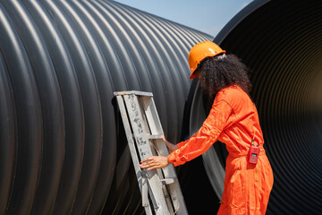 Engineers collaborate inside a massive steel pipe, constructing a tunnel for an industrial pipeline...