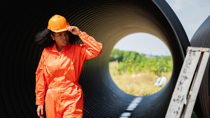 Engineers collaborate inside a massive steel pipe, constructing a tunnel for an industrial pipeline...