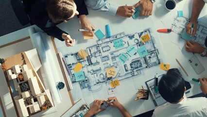 Top aerial view of project manager or civil engineer writing at blueprint and planning building...
