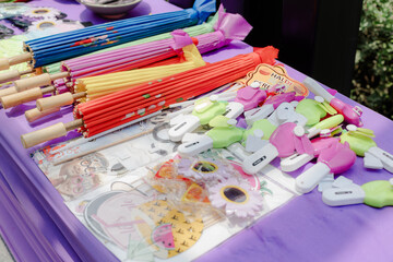 Assortment of colorful paper umbrellas and novelty items displayed on a purple table, evoking a festive atmosphere. Ideal for party favors or decorations.