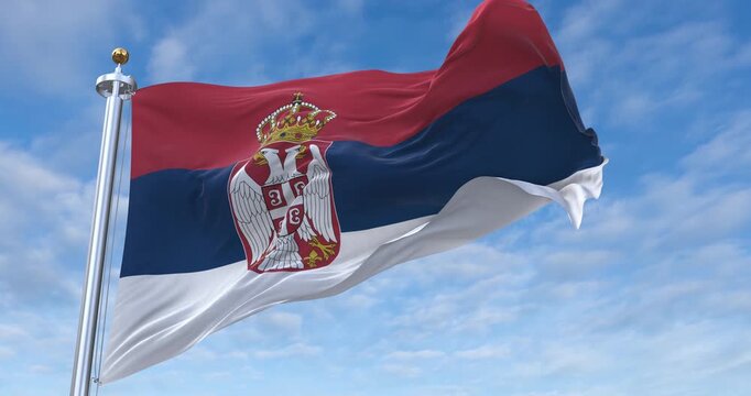 Serbia flag with flagpole waving in wind, rolling clouds background looping, 4K video (Perfect Loop)