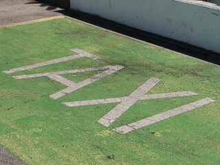 The word TAXI in old, broken letters in the parking lot—this image can be used to illustrate the problems facing the taxi industry due to alternative transportation services.