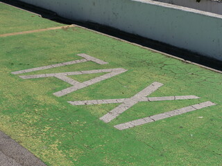 The word TAXI in old, broken letters in the parking lot—this image can be used to illustrate the problems facing the taxi industry due to alternative transportation services.