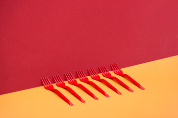 Abstract still life with red forks on a colored background