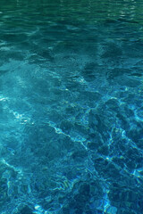The background is abstract. Sun glare on the surface of the pool. Light ripples and a soothing atmosphere.