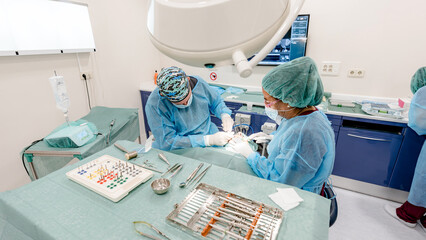 Dental professionals performing implant surgery