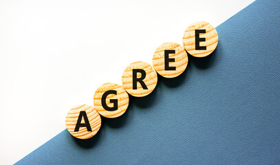 Agree symbol. Concept word Agree on beautiful wooden circles. Beautiful white and blue background....