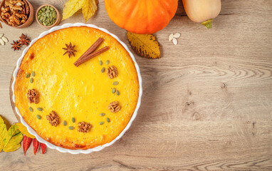 Homemade pumpkin pie decorated with walnuts, seeds, and spices for Thanksgiving celebration. top...