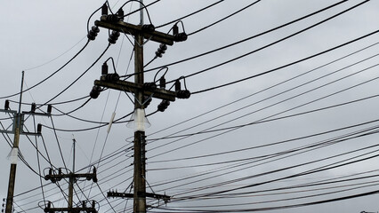 Power Grid and Sky: A network of power lines stretches across a gray, overcast sky, creating a...