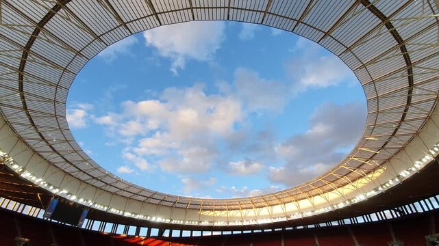 View of a blue sky with clouds from inside a stadium. 