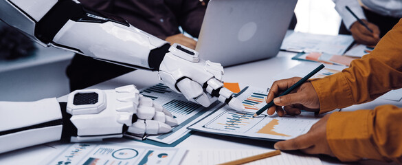 A unique business meeting scene where human and robot collaborate on data analysis, showcasing technology integration in modern workspace dynamics.Noogenesis