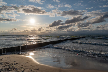 Baltic sea seascape at sunset, Sianozety resort in Poland, wooden breakwater and waves