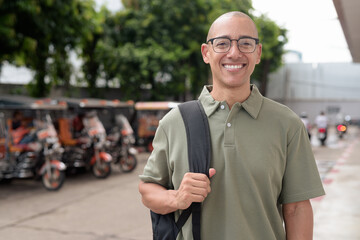 Hispanic man tourist in Thailand with backpack and tuk tuk taxis exploring Southeast Asia