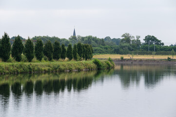 Natural and industrial reflections at the Grand Large water pond in Mons, Hainaut, Belgium