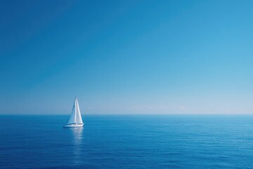 Obraz premium Sailboat gliding across calm blue ocean under clear sky, serene