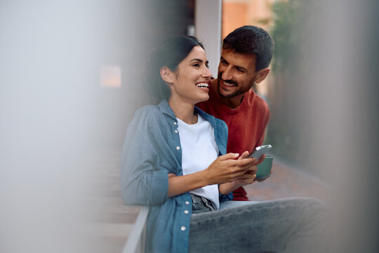 Young happy couple enjoying on porch of their new house.