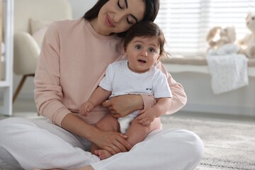 Happy mother with her cute little baby at home