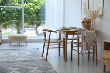 Stylish table setting, chairs and decor in dining room. Interior design