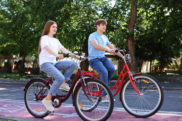 Obraz premium Teenage girl and boy riding bicycles on city street