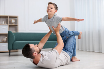 Father and his son spending time together on warm floor at home. Heating system