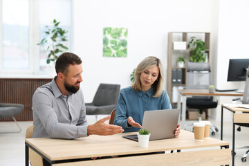Business partners working with tablet at table in office