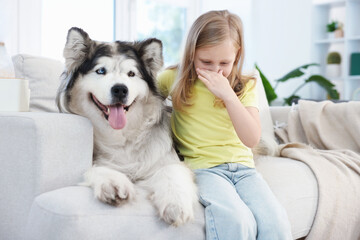 Girl suffering from allergy with her dog at home