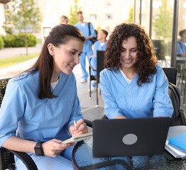 Medical students studying together in outdoor cafe, selective focus