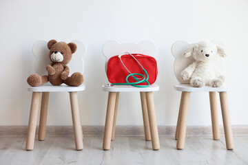Pediatrician concept. Toys, medical bag and stethoscope on chairs in clinic