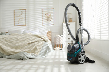 One vacuum cleaner on floor in bedroom. Household appliance