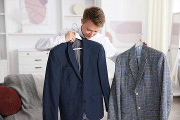 Getting ready. Young man choosing clothes at home
