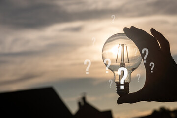 Light bulb and sunrise with question marks.