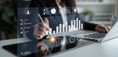A business professional engages with a digital tablet to analyze data trends, showcasing modern...