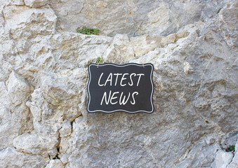 Latest News symbol. Stone wall with words Latest News. Beautiful stone background. Business and...