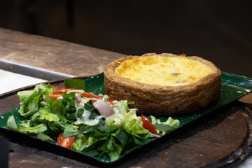 A serving of raw vegetable salad next to a small pie