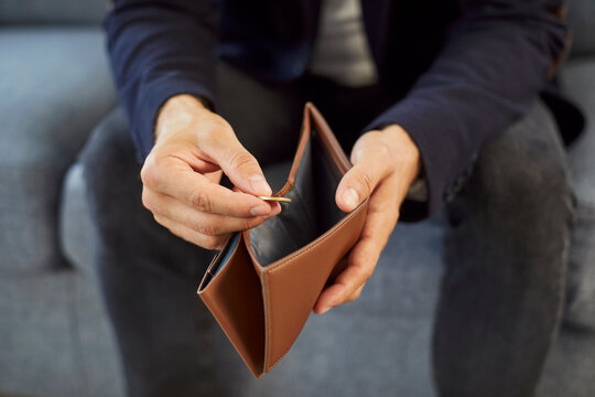 Hands of poor man counting cash money, holding open empty wallet. Worried lonely person with financial troubles and budget deficit sitting with one coin in fingers. Poverty, bankruptcy concept - Powered by Adobe
